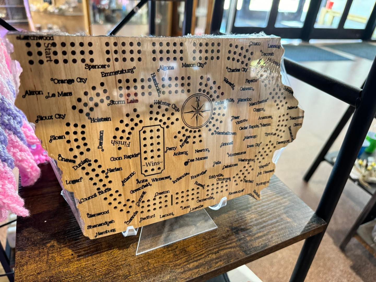 Iowa-shaped wooden cribbage board with engraved town names and a compass rose