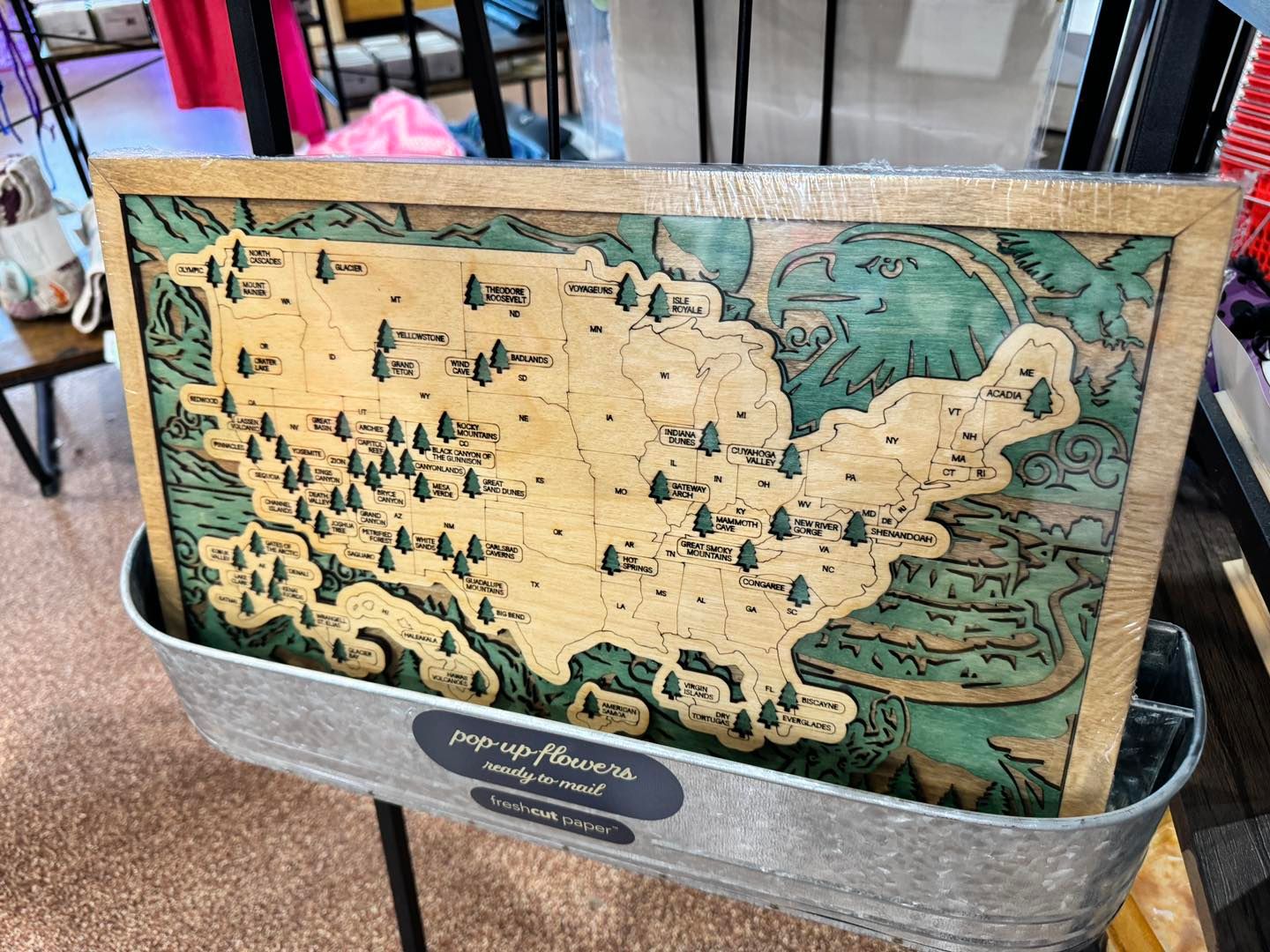 Layered wood map of the United States marking every national park, in natural and green stained layers